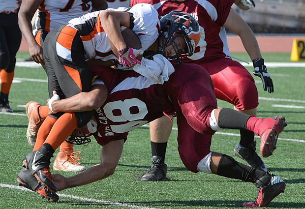 A West Campus (Sacramento, Calif.) defender attempts to bring down the Marysville (Calif.) ball carrier.