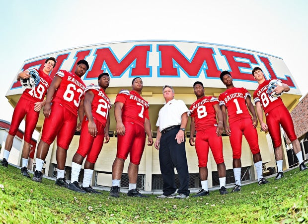 Head coach Jay Roth poses with his players in front of the team's locker room on campus.