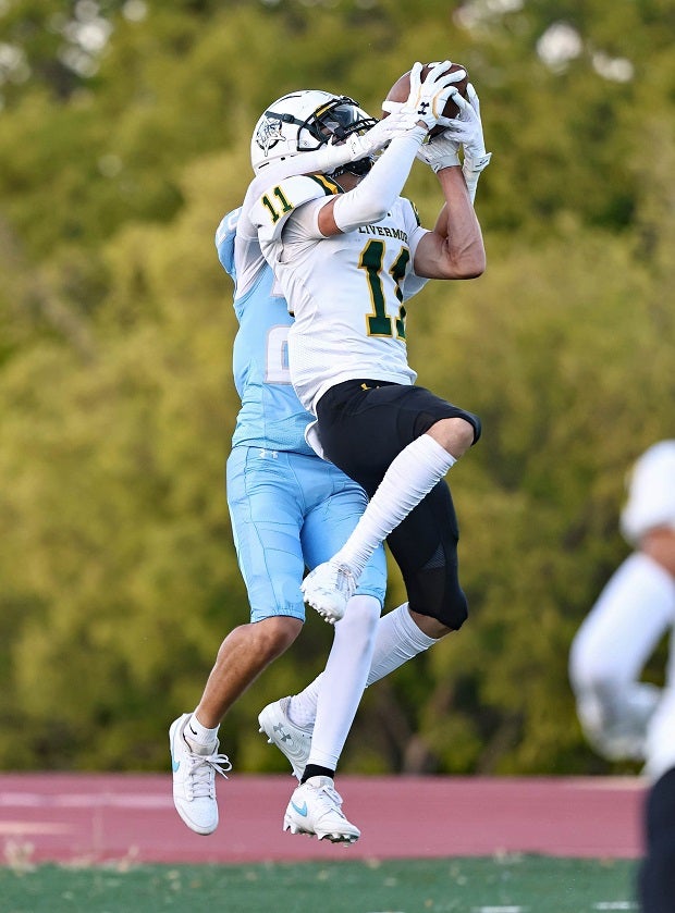 Livermore junior A.J. Carey skies for an end-zone interception against Hillsdale in the Cowboys' season-opening loss. (Photo: James Regan)