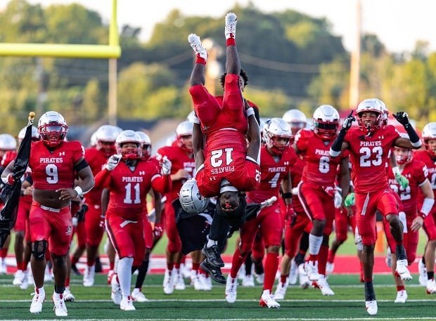 Page running back Floribert Kizumina leads the Pirates on the field with a back flip in their season opener against Dudley. (Photo: Joshua Chayer)
