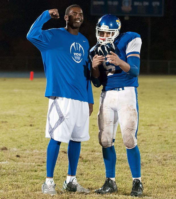 Randy Moss and his son Thad have fun posing after the game.