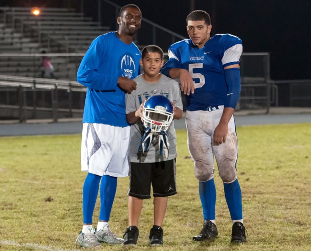 Randy Moss poses with his sons, Montigo and Thad, following Thursday's game.