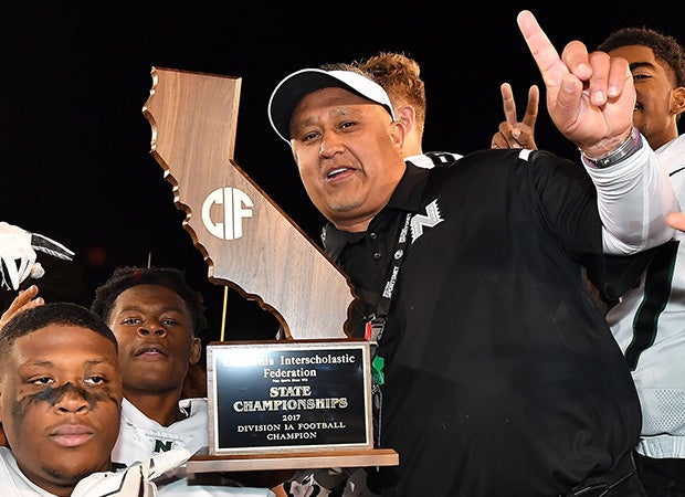 Head coach Manuel Douglas proudly displays the championship trophy following his team's victory in last year's CIF Division 1-A state title game. 