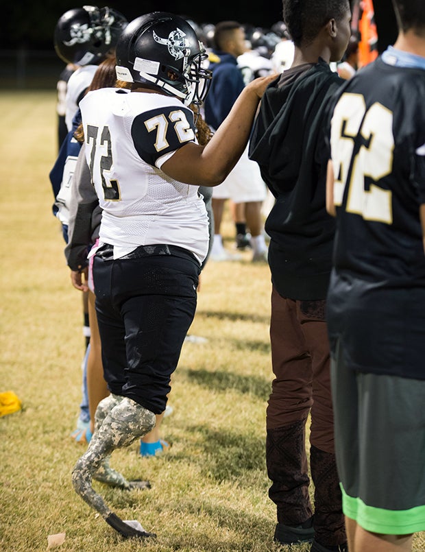 Martel steadies himself on a classmate's shoulder along the sideline.