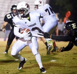 Lakeside's Junior Running Back Josh Jones
eludes an Evans defender during their
annual rivalry game.