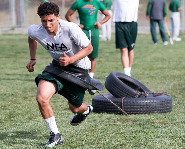 Quarterback Anthony Sweeney drags tires during a workout session before the photo shoot.