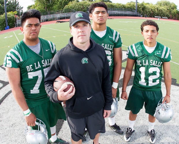 De La Salle head coach Justin Alumbaugh poses along with players (left to right) Boss Tagaloa, Devin Asiasi and Anthony Sweeney during a photo shoot at the school's football stadium in May.