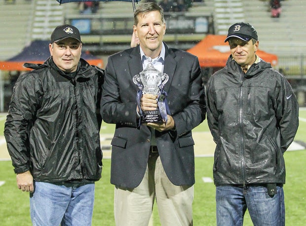 MaxPreps Founder and President Andy Beal prepares to award the MaxPreps Cup to Bentonville High administrators on Friday.