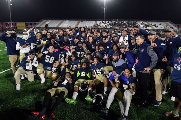 Mater Dei Catholic players and coaches pose after winning their first state championship.