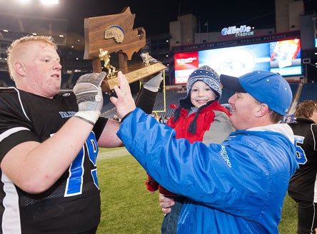 Nathan Chrzanowski, left, and coach Matt Triveri celebrate a Massachusetts Super Bowl title Saturday in Foxboro. Triveri has taken a downtrodden program to new heights since taking over.