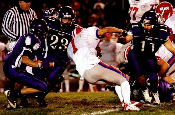 Bishop Miege's Bobby Germinder (1) tries to get extra yards as three Louisburg defenders close in.