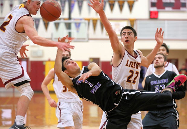 College Park (Calif.) guard Nick Lombardi attempts an off-bounce shot that deflects off the face of Liberty's Carson Musgrove during a game in the Stonebarger Tournament.