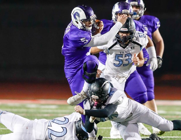 St. Anthony (Calif.) quarterback John Buksa runs over two Pleasant Valley defenders during the CIF Division 4-A state championship game.