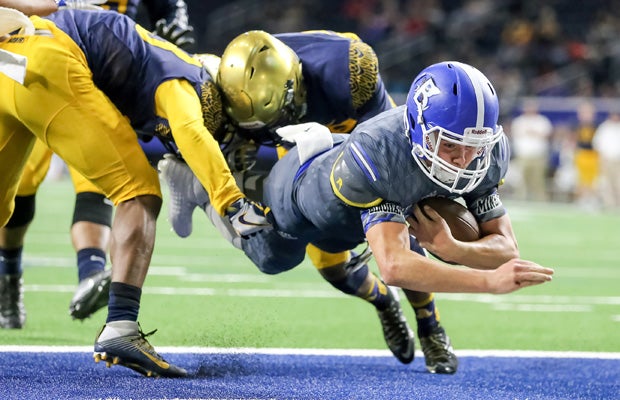 Bingham (Utah) quarterback Matt Degn splits two St. Thomas Aquinas (Fla.) defenders while diving into the end zone for a touchdown during a game in the Geico State Champions Bowl Series at The Star in Frisco (Texas).