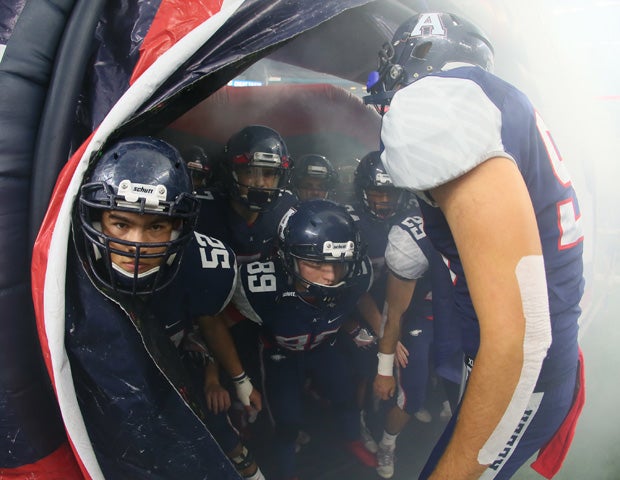Allen (Texas) senior center Mason Morris peers out of the Big A inflatable before leading his team onto the field prior to their UIL playoff game against Duncanville at AT&T Stadium.