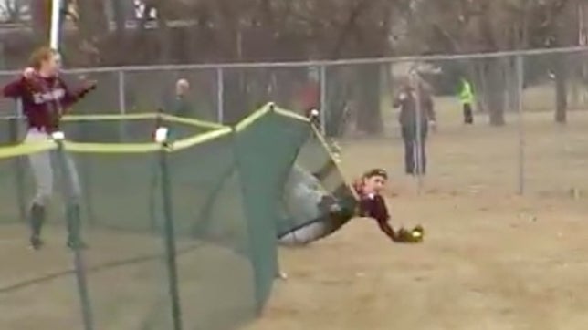 Taiylor Ellingson of Grand Forks Central (ND) somehow dives through the outfield fence and makes a spectacular grab.