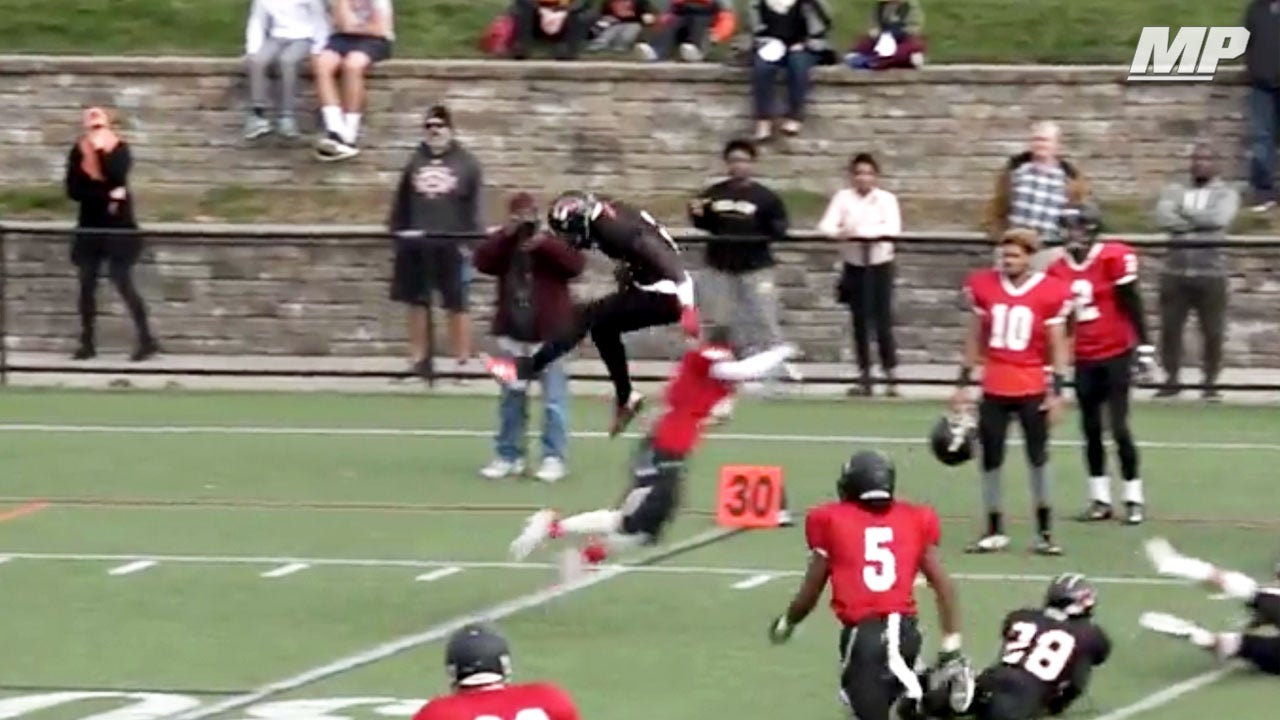 Michigan commit hurdles over defender